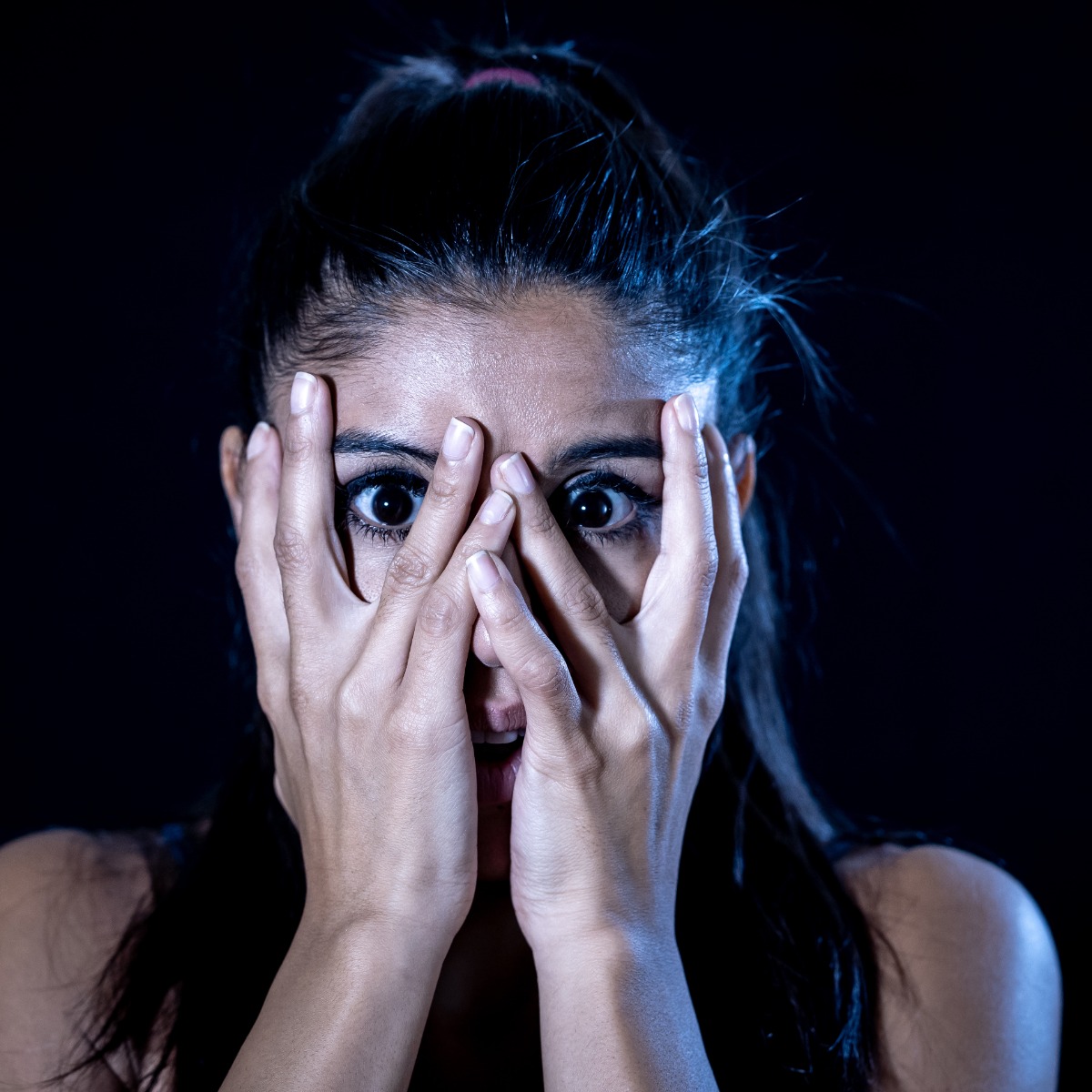 Women covering her eyes with both hands